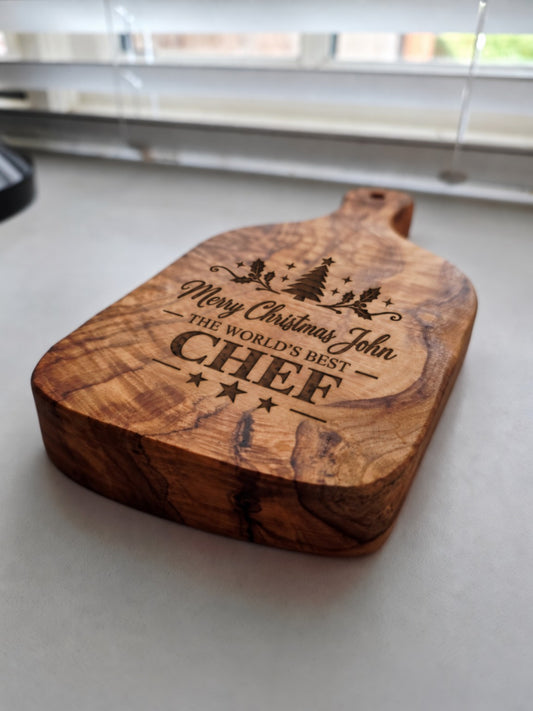 Close up of personalised Merry Christmas engraved olive wood chopping board
