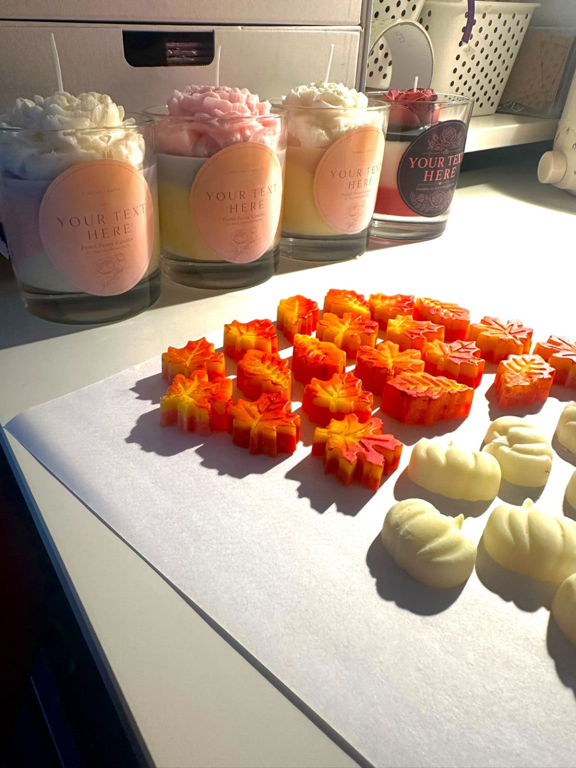 Handmade autumn candles and pumpkin leaf wax decorations being prepared