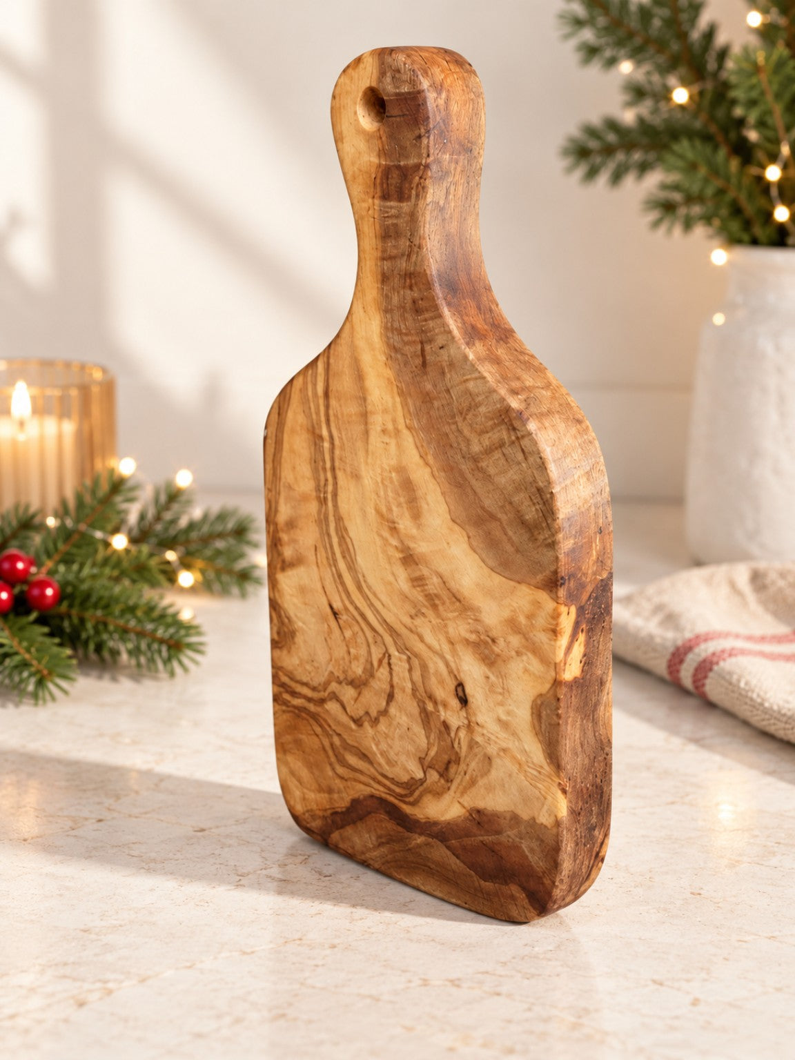 Premium natural olive wood serving board photographed in a festive setting