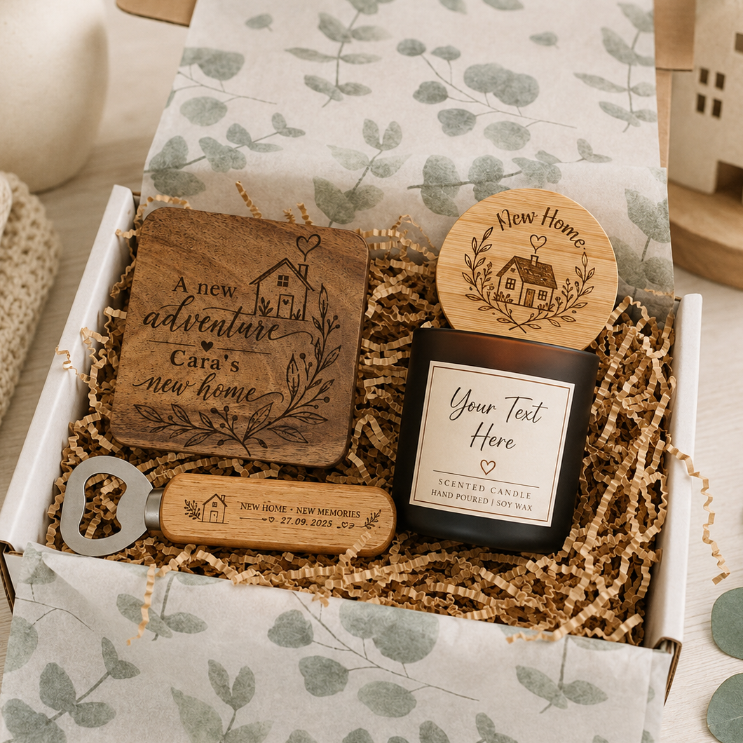 A curated gift box set containing personalized wooden home decor and a candle. The set includes a square wooden plaque engraved with 'A new adventure Cara's new home', a round wooden lid with a house engraving, a black glass candle jar with a white label reading 'Your Text Here', and a wooden bottle opener engraved 